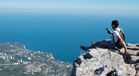 Турист фотографируется на вершине горы Ай-Петри в Крыму