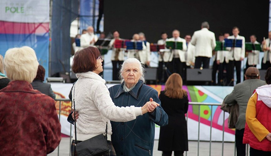 Люди танцуют на набережной